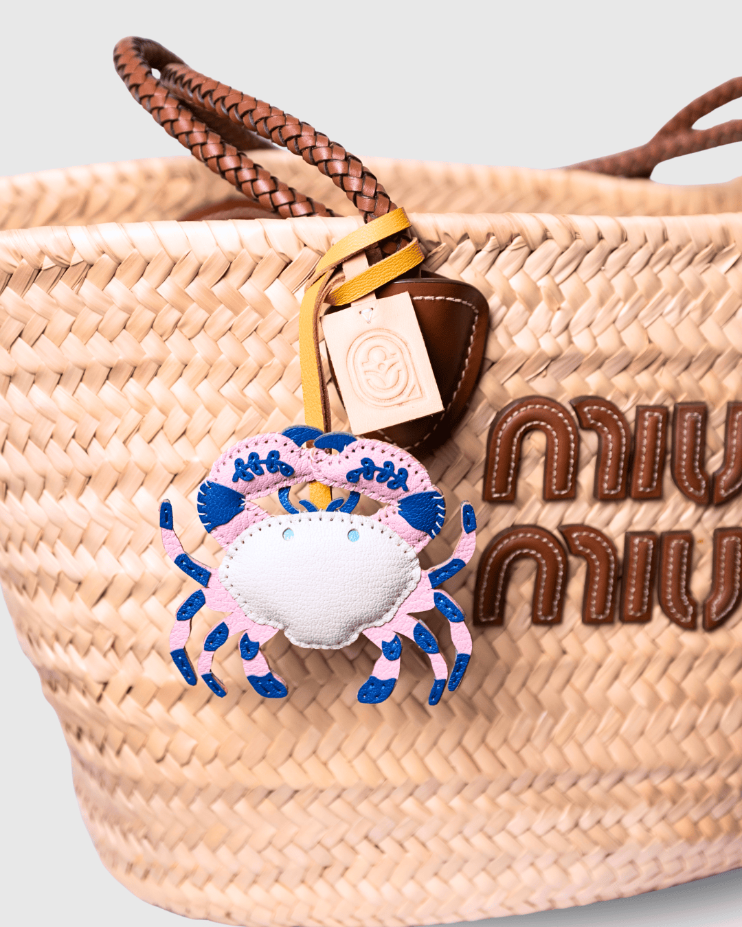 Straw tote bag with crab charm.