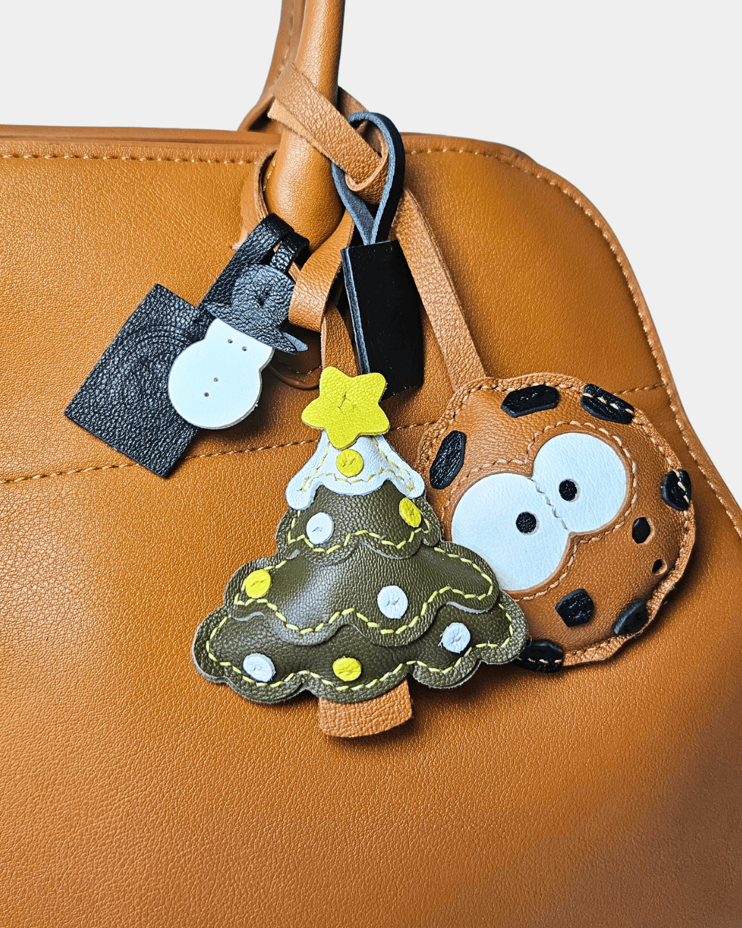 Tan purse with Christmas tree, cookie, and snowman charms.