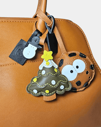 Tan purse with Christmas tree, cookie, and snowman charms.