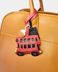 Brown leather bag with red bus charm.