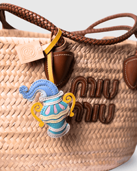 Straw tote bag with charm and logo.