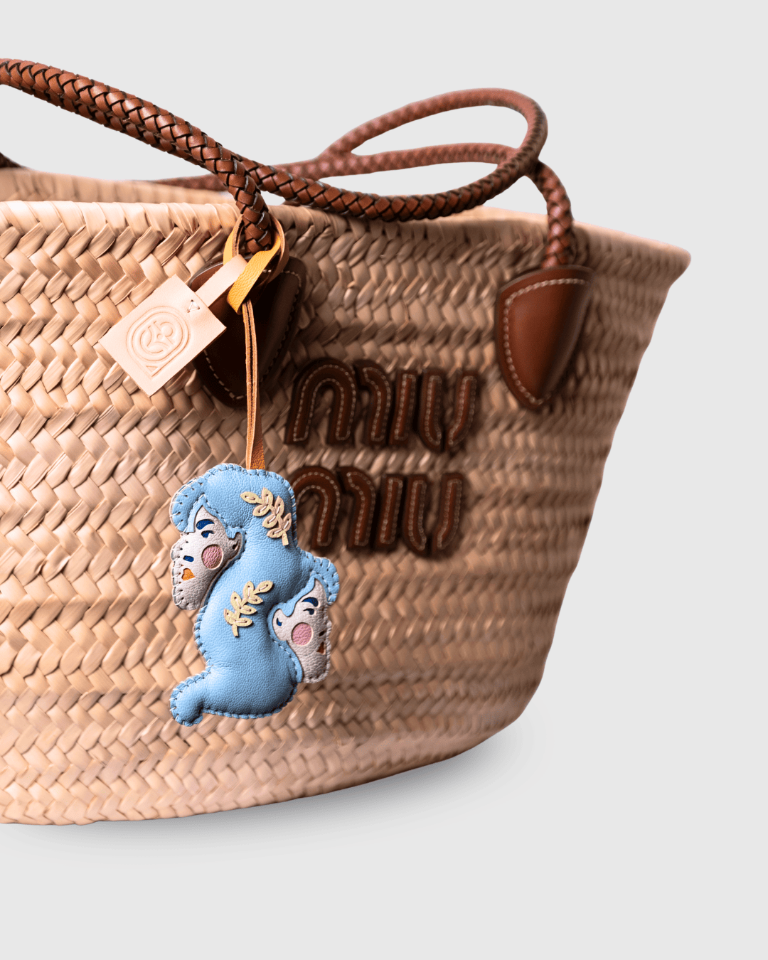 Woven straw tote bag with a charm.