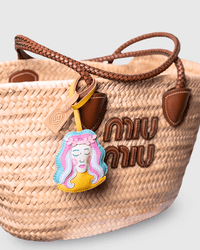 Straw bag with charm and logo.