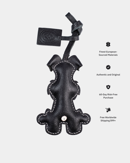 Black leather dog toy with a strap on a white background