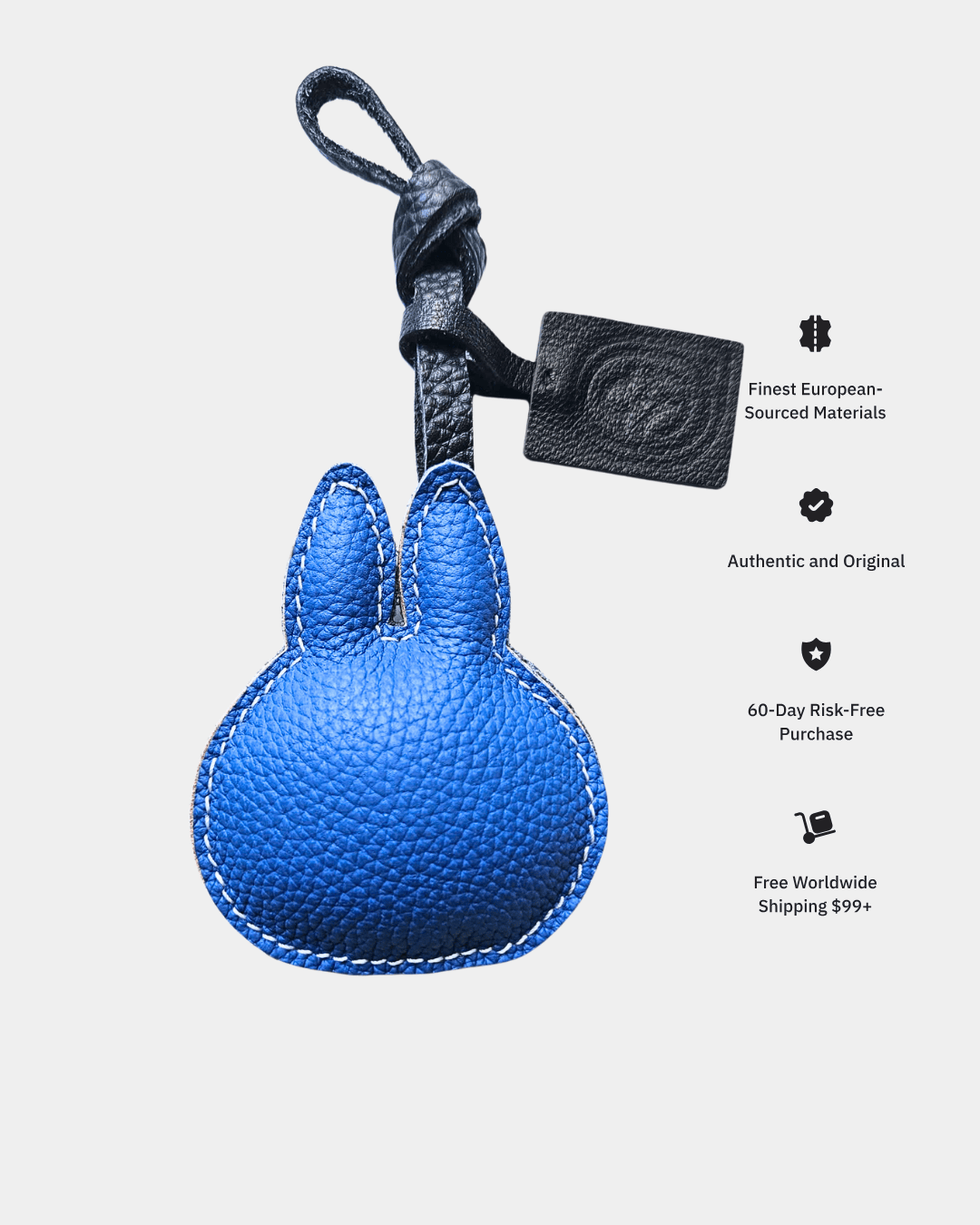 Blue leather rabbit-shaped keychain with a black strap on a light gray background