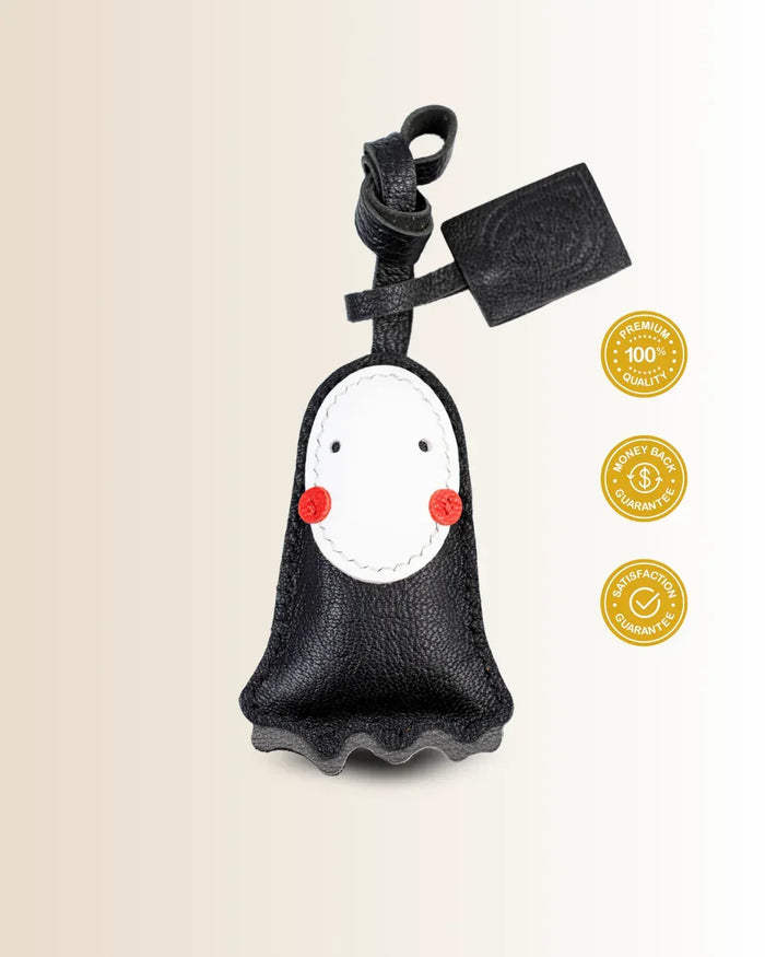 Black goatskin leather bag charm with no-face character shaped with a tag on a beige background