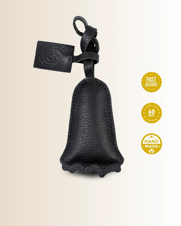 Black leather goatskin bag charm with no-face character shaped with a tag on a beige background