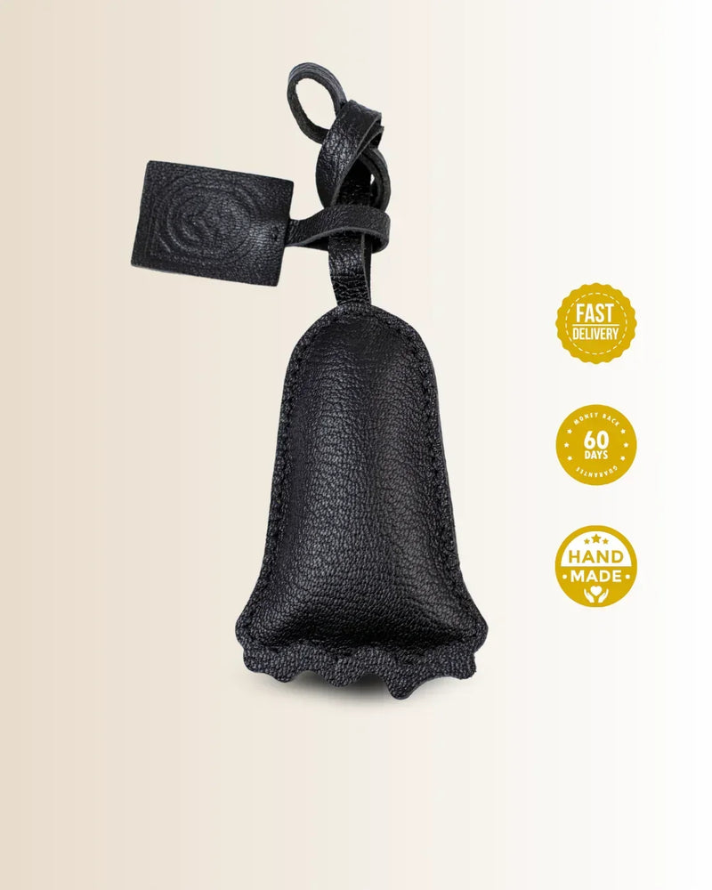 Black leather goatskin bag charm with no-face character shaped with a tag on a beige background