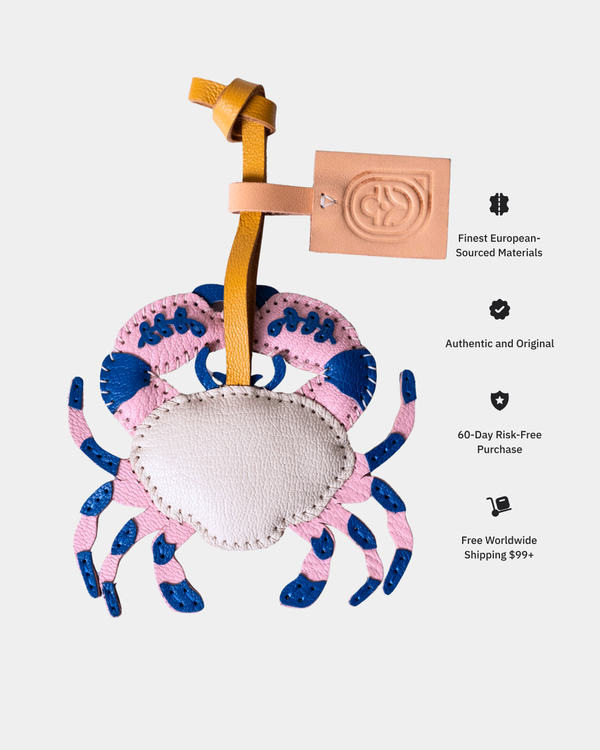 Pink and blue crab-shaped product with a strap on a light gray background