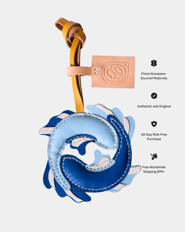 Blue and white leather bag charm with gold accent on a light gray background