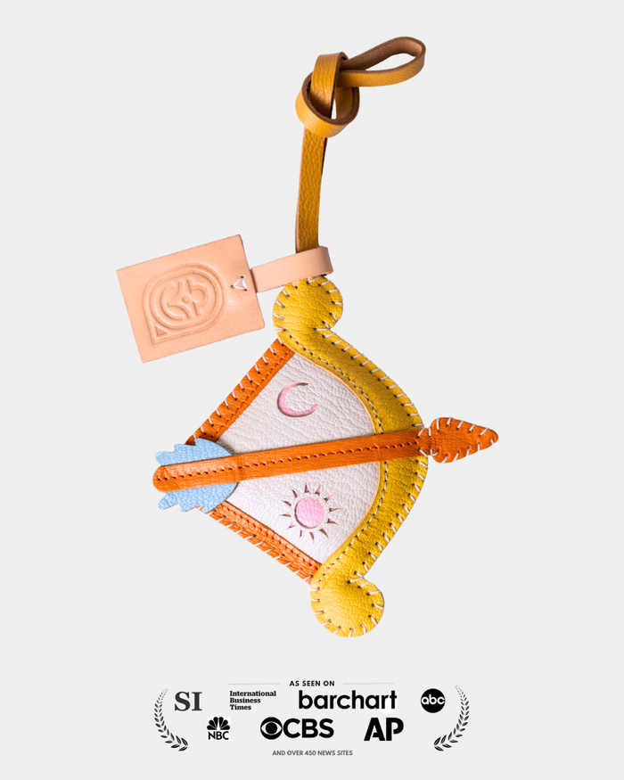 Colorful leather bag charm with a Sagittarius horoscope sign design on a light gray background