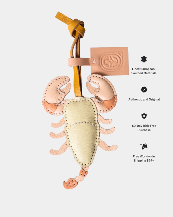Leather scorpio-shaped keychain with branding on a white background